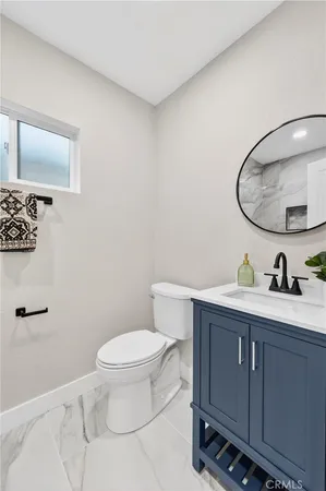 a bathroom with a toilet a sink and mirror