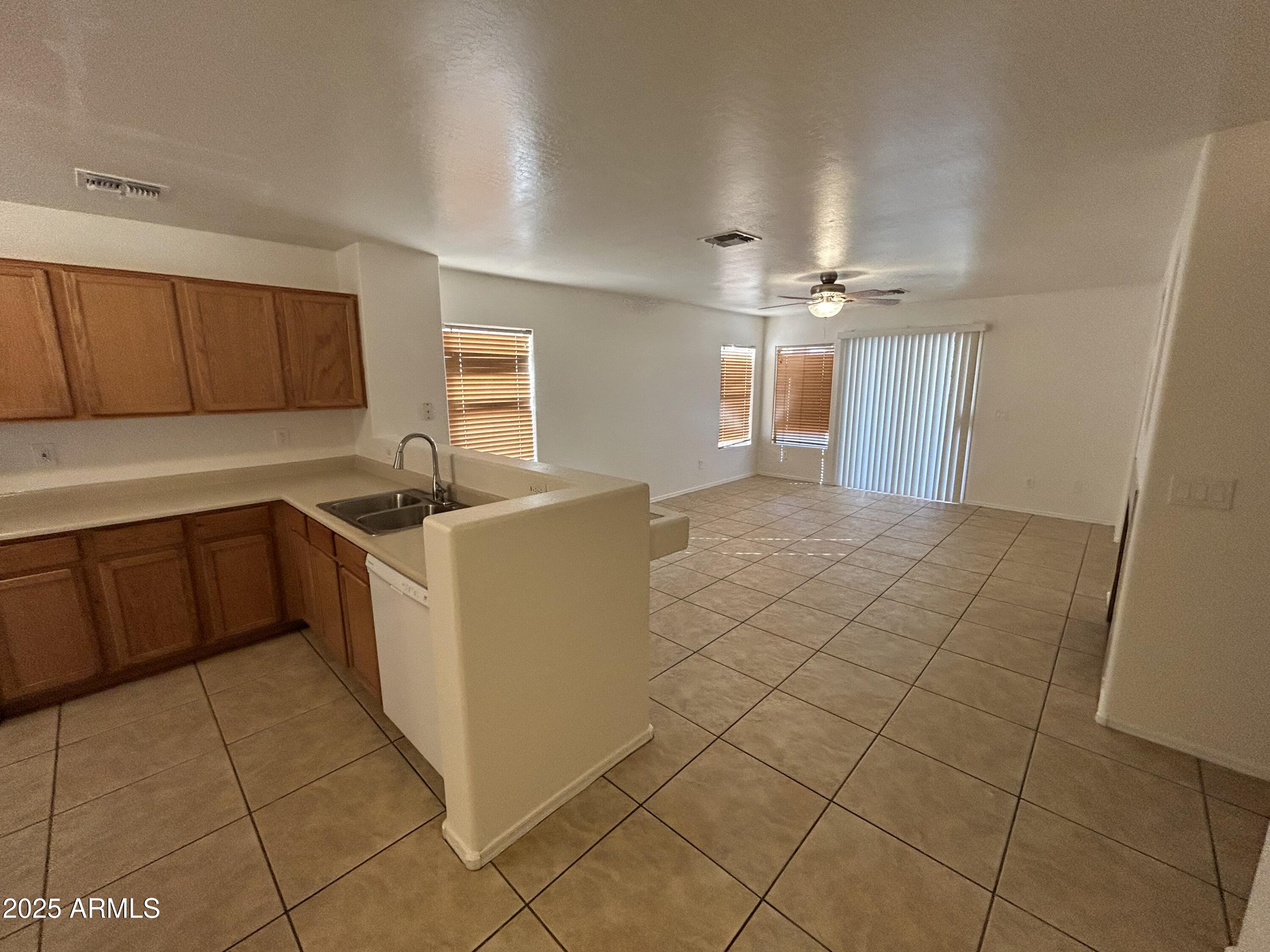 1602 West Alta Vista Road Phoenix, AZ 85041 - Photo 2 of 13 a kitchen with a sink a stove cabinets and a window