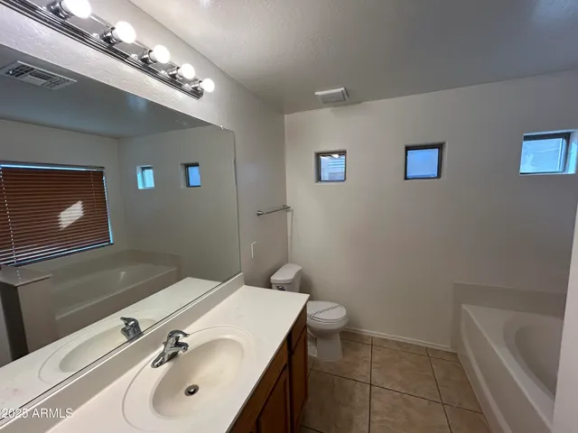 a bathroom with a sink a tub and a mirror