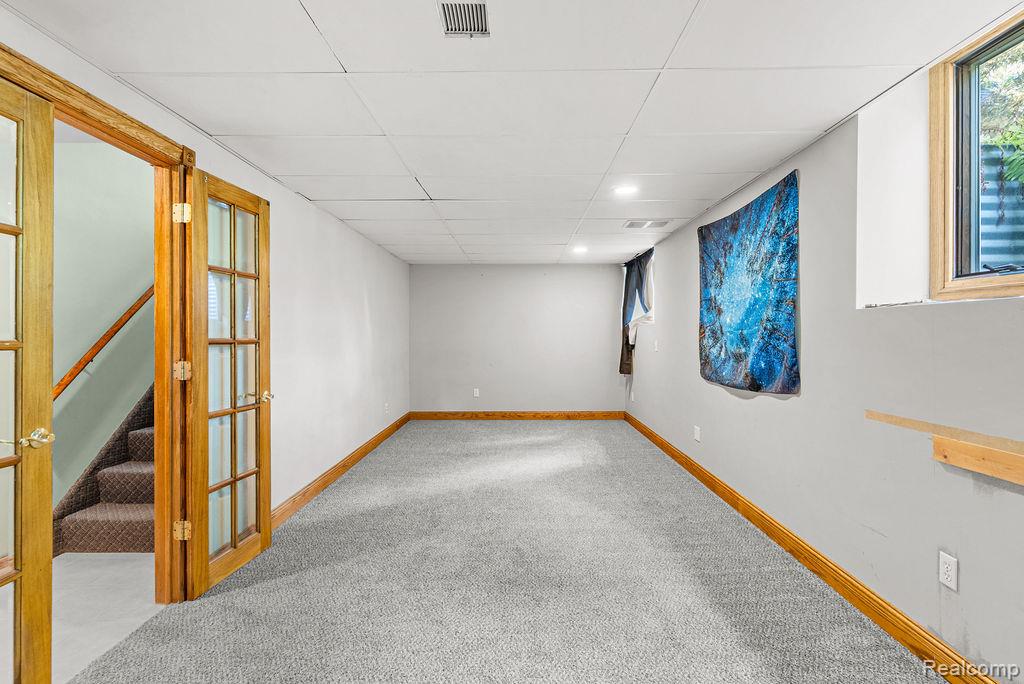 1476 County Farm Road Howell, MI 48843 - Photo 35 of 53 Unfurnished room featuring stairs, a paneled ceiling, light carpet, french doors, and recessed lighting