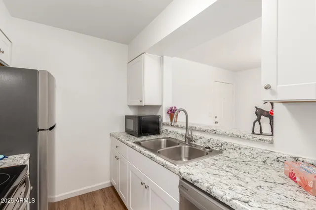 a kitchen with stainless steel appliances granite countertop a sink stove and refrigerator