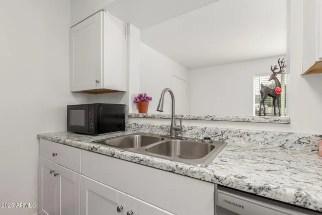 a kitchen with granite countertop a sink and a stove