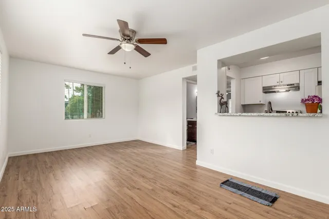 a view of a room with wooden floor and a ceiling fan