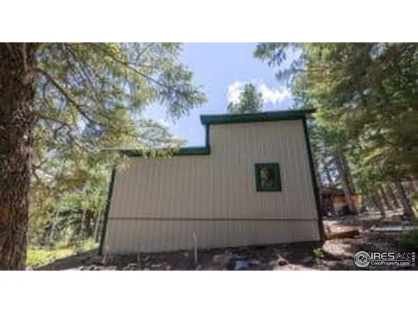 a view of a house with backyard and trees