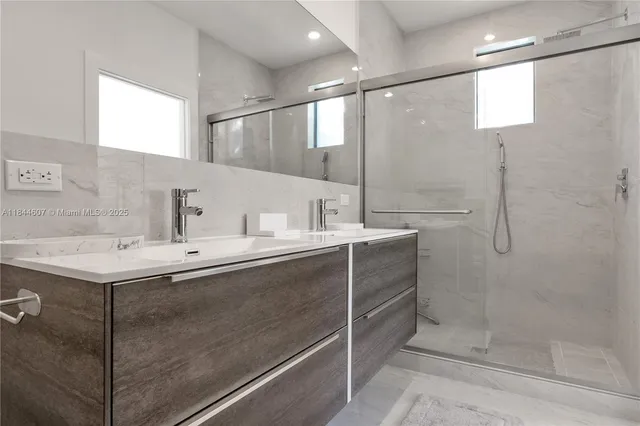 a bathroom with a shower sink and mirror