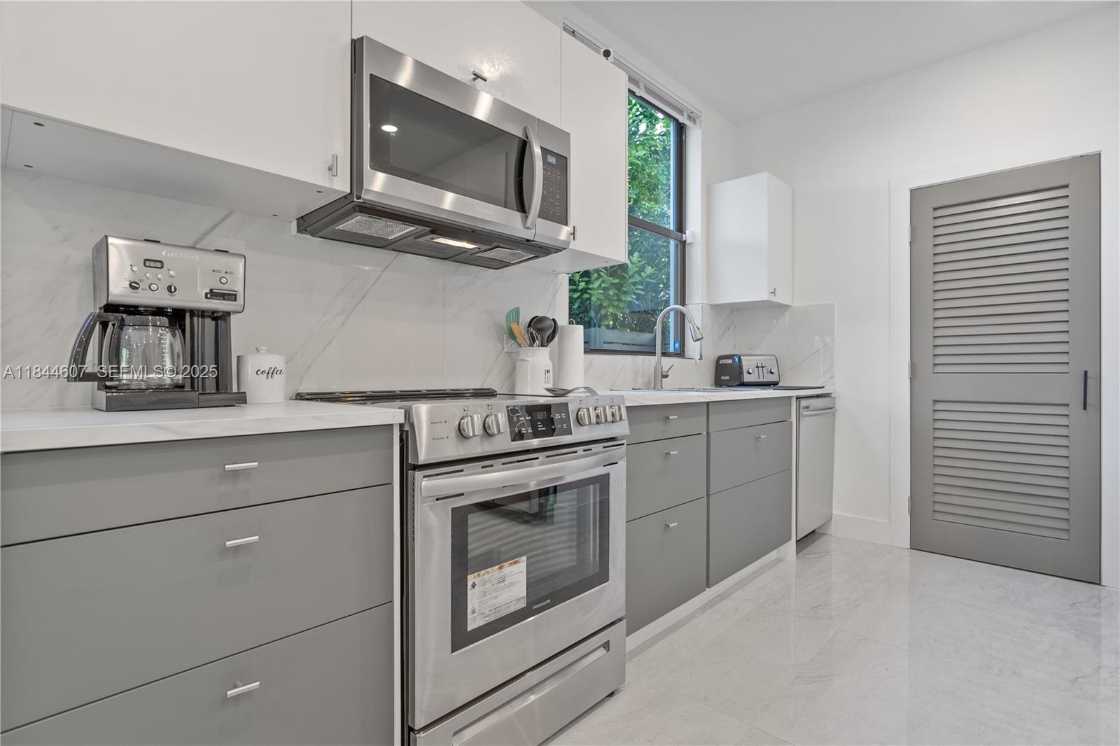 2887 Southwest 33rd Avenue Miami, FL 33133 - Photo 33 of 38 a kitchen with stainless steel appliances granite countertop a stove a sink and a microwave