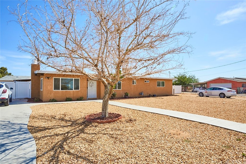 23039 Lucilla Road Apple Valley, CA 92308 - Photo 1 of 1 a front view of a house with a yard and garage