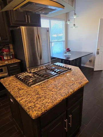 a kitchen with granite countertop a sink a stove and refrigerator