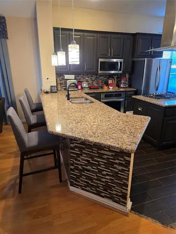 a kitchen with stainless steel appliances a stove a microwave a sink and cabinets