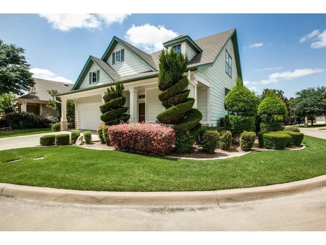 a front view of a house with a garden and plants