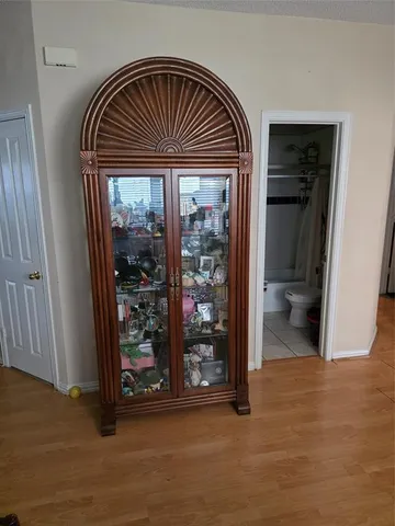 a view of hall way with wooden floor and a bathroom