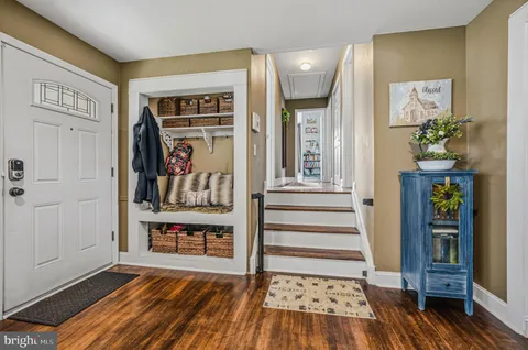 a view of a hallway with wooden floor and staircase