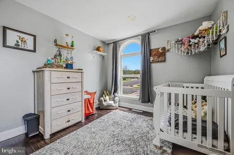a view of a bedroom with baby crib and furniture