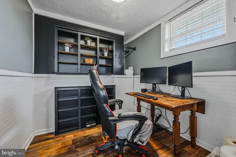 a view of a workspace with furniture and wooden floor
