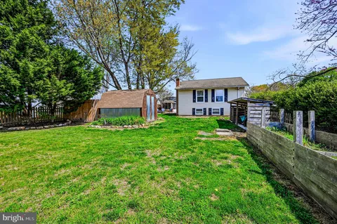 a view of a house with backyard and a tree