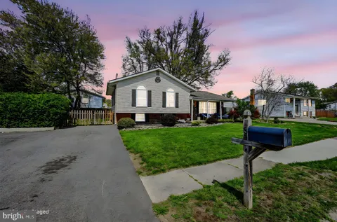 a front view of a house with a yard and green space