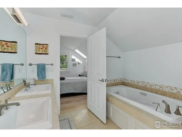 a bathroom with a tub a sink and a mirror