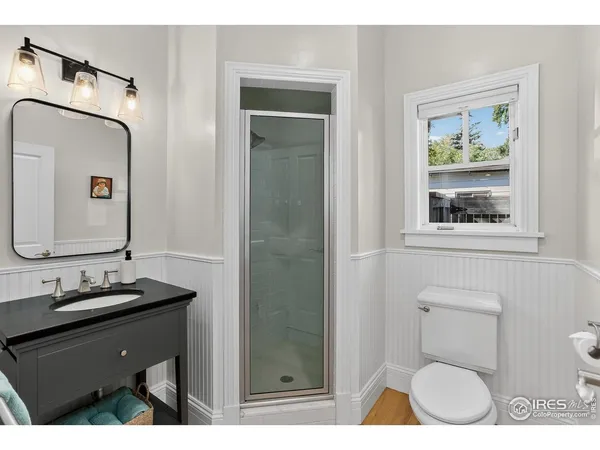 a bathroom with a toilet a sink a mirror a vanity and window