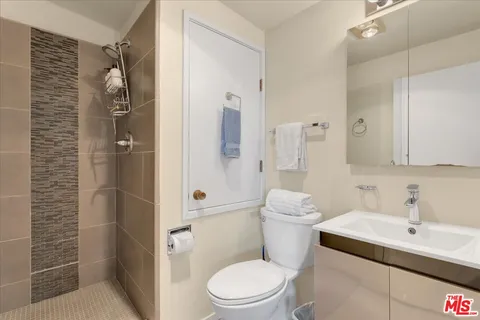 a bedroom with a bed and a lamp on dresser