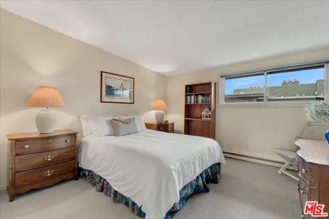 a bedroom with a bed a large window with outer view and couch