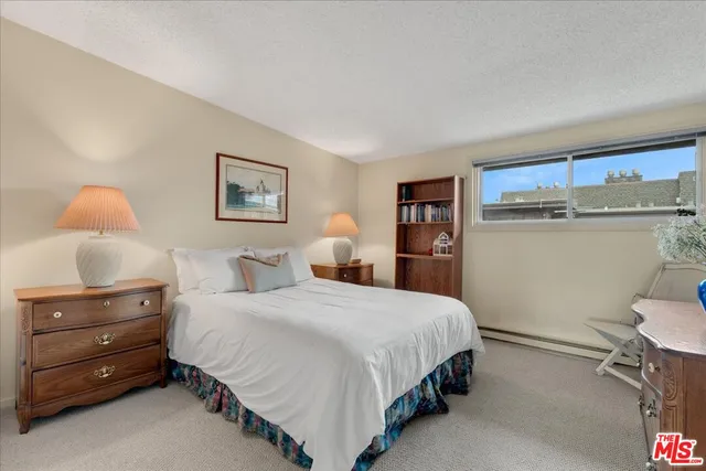 a bedroom with a bed a large window with outer view and couch