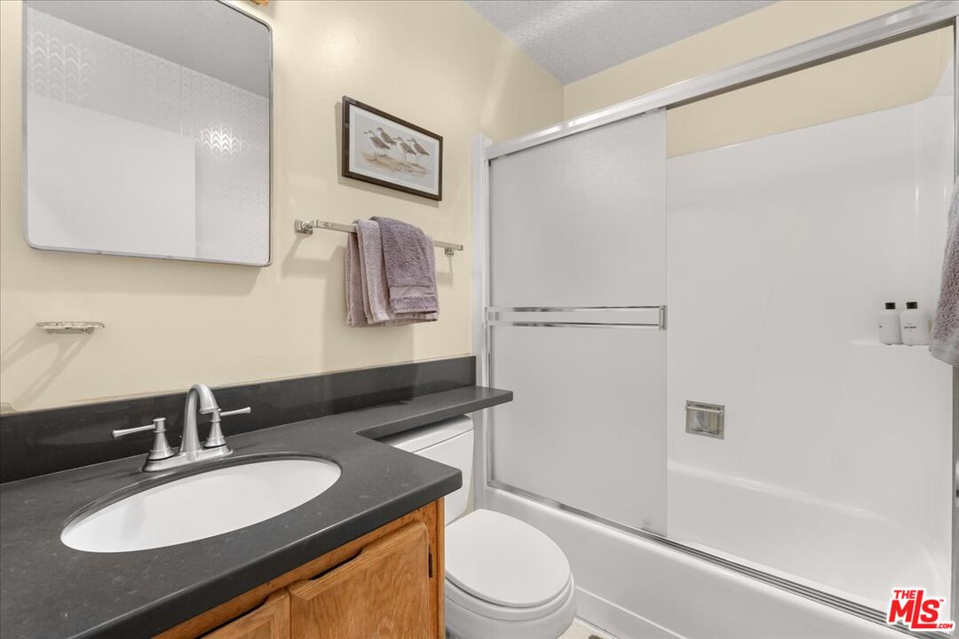 67 Pelican Point Watsonville, CA 95076 - Photo 19 of 25 a bathroom with a granite countertop sink toilet a mirror and shower