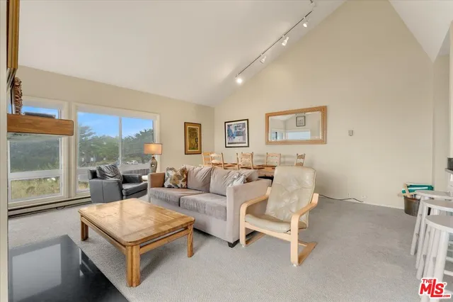 a living room with furniture and a view of kitchen