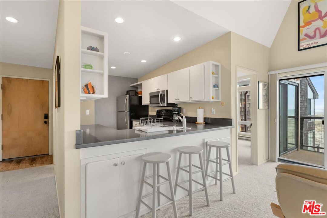 67 Pelican Point Watsonville, CA 95076 - Photo 10 of 25 a kitchen with stainless steel appliances kitchen island granite countertop a refrigerator and cabinets