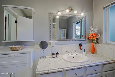 a bathroom with a granite countertop sink and a mirror