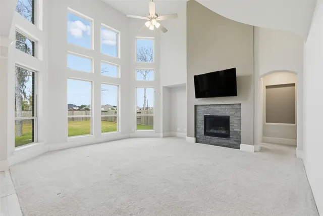 a view of an empty room with a fireplace and a window