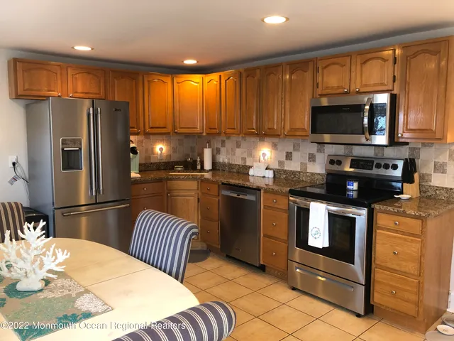 a kitchen with stainless steel appliances a stove refrigerator sink and microwave