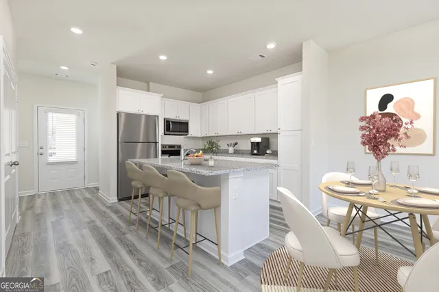 a kitchen with stainless steel appliances granite countertop a refrigerator sink and white cabinets