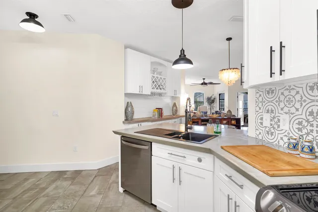 a kitchen with stainless steel appliances granite countertop a sink a stove and a wooden floors