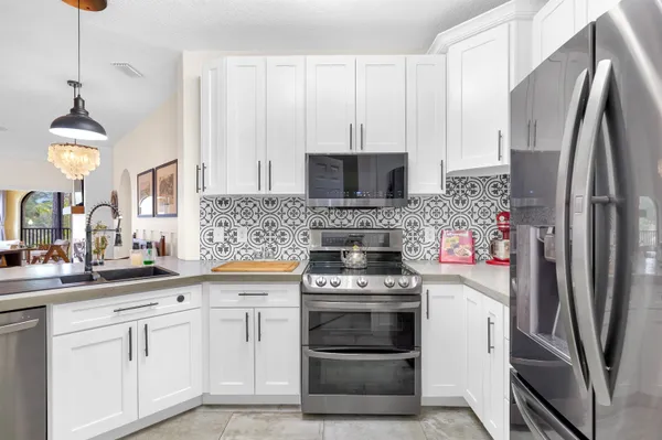 a kitchen with white cabinets and stainless steel appliances