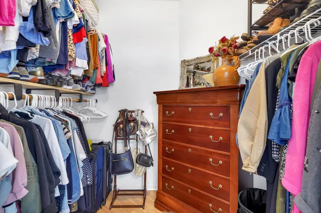 a view of walk in closet with clothes and shoes