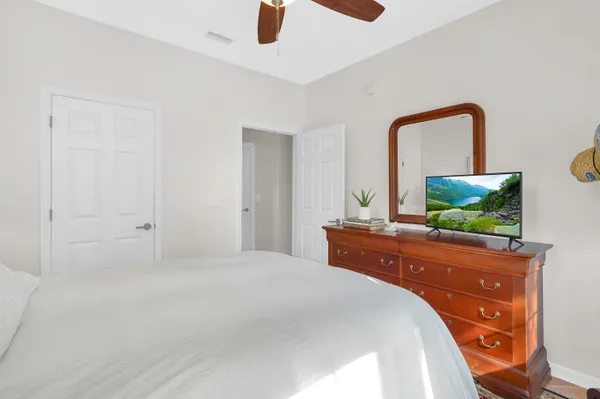 a bedroom with a bed and a flat tv screen on dresser