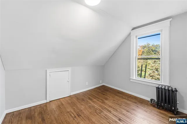 a view of a hallway with wooden floor and entryway
