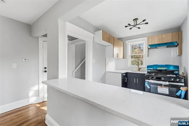 a kitchen with a stove a refrigerator and a window