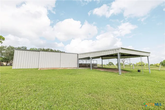 a view of a deck with a big yard and a large tree