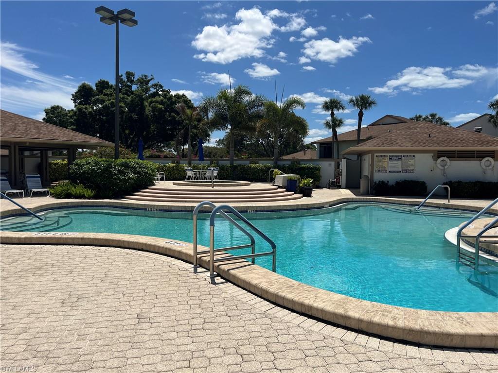 513 Lake Louise Circle, Unit 202 Naples, FL 34110 - Photo 14 of 15 a view of a house with pool and chairs