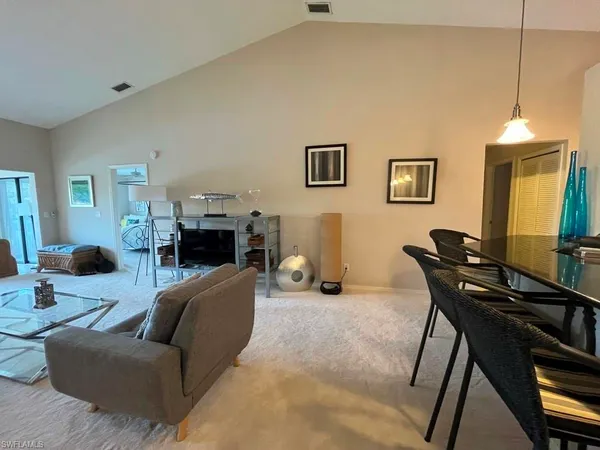 a room with a table chairs and a chandelier
