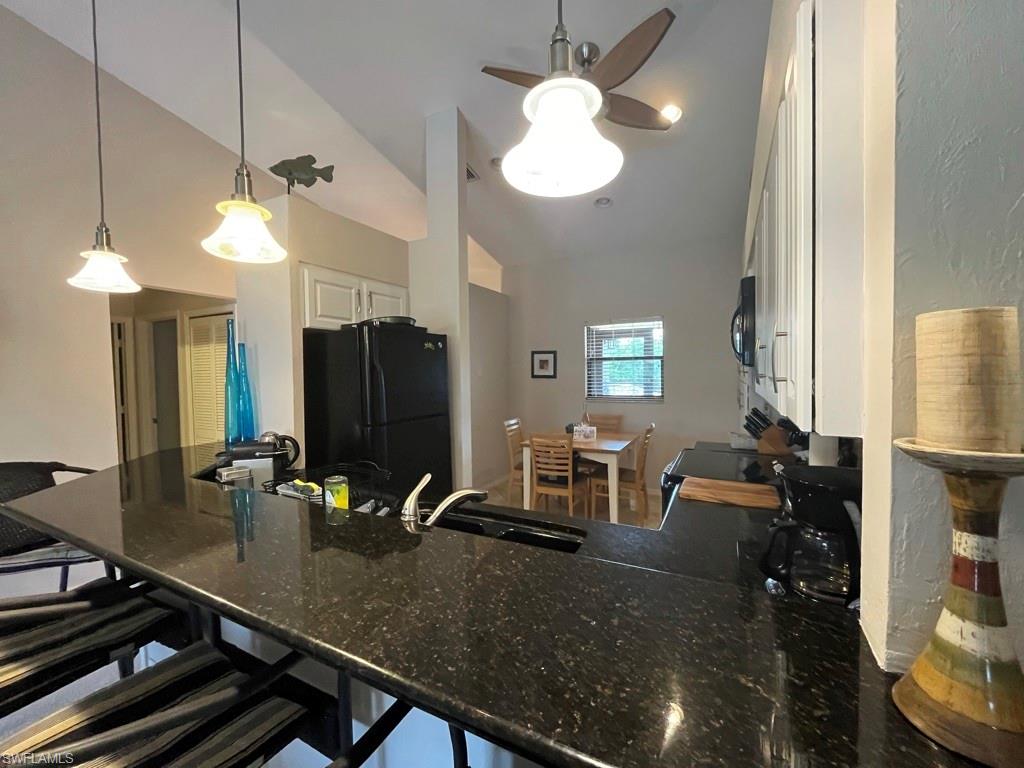 513 Lake Louise Circle, Unit 202 Naples, FL 34110 - Photo 8 of 29 a room with a table chairs and a chandelier