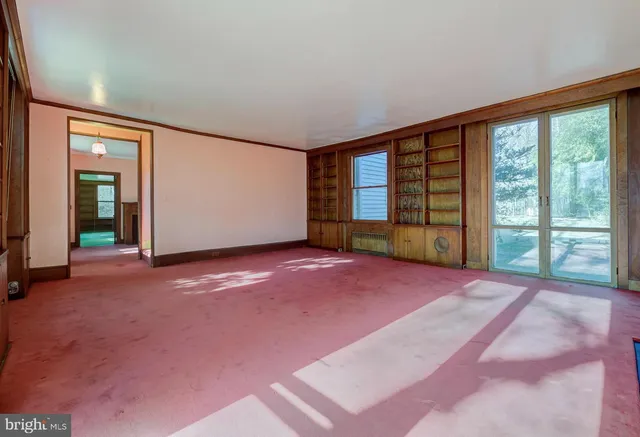 an empty room with windows and mirror