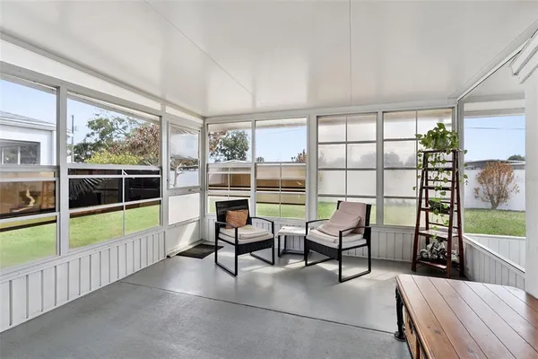 a view of a room with furniture and large windows