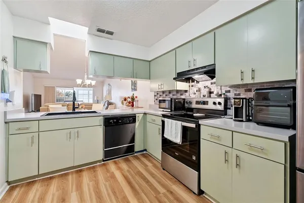 a kitchen with granite countertop white cabinets and white appliances