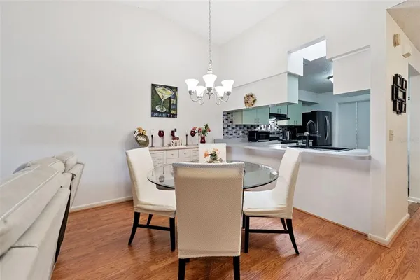 a dining room with furniture a chandelier and wooden floor