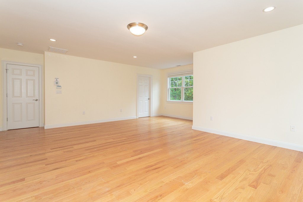 18 Shade Street Lexington, MA 02421 - Photo 17 of 23 a view of an empty room with wooden floor and a window