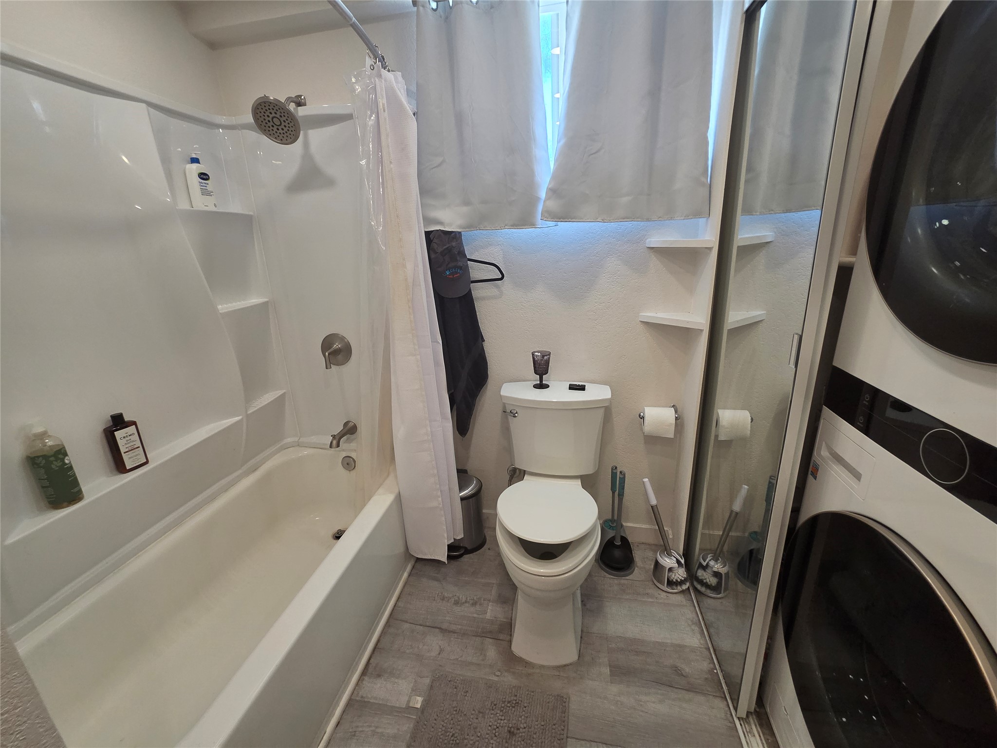 1106 The High Road, Unit B Austin, TX 78746 - Photo 7 of 8 Functional full bathroom offering a tub and shower combination with adjacent laundry facilities.