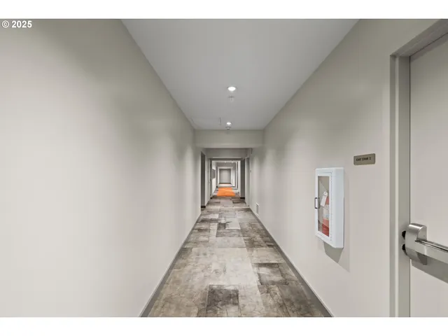 a view of a hallway with wooden floor and a living room