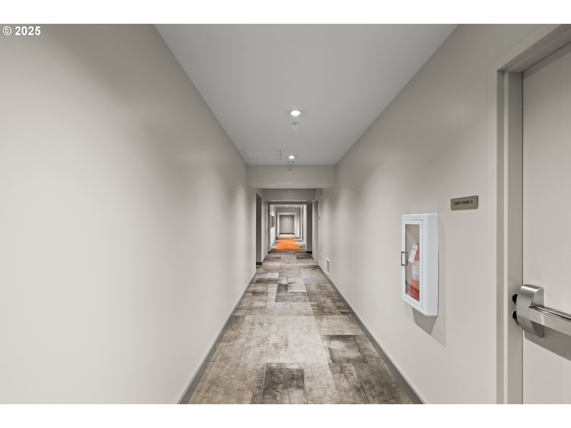 841 Southwest Gaines Street, Unit 714 Portland, OR 97239 - Photo 11 of 48 a view of a hallway with wooden floor and a living room